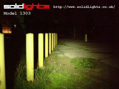 1303 shining along row of yellow poles at 4 foot intervals